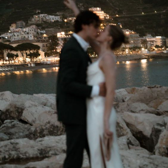 Bride and bridesmaids in elegant wedding dresses posing in an Italian villa setting - destination wedding dress rental UK