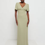 Woman wearing Flattering V-neckline Edie Chiffon Maxi bridesmaid dress in olive green,  under Bust detailing with floaty cap sleeves against a white background