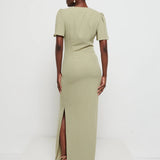 Woman wearing a Edie chiffon maxi Olive with a slit on a white background