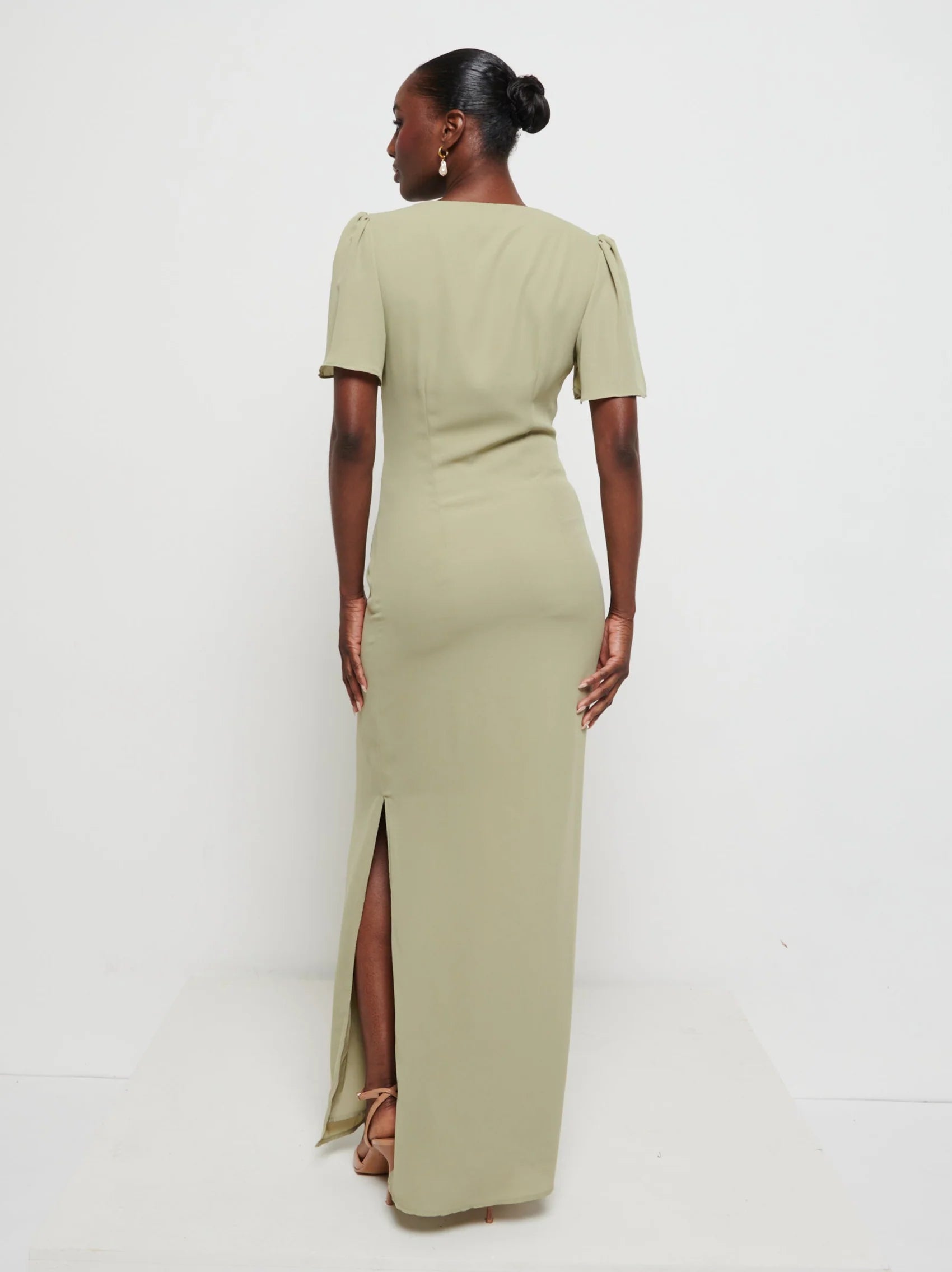 Woman wearing a Edie chiffon maxi Olive with a slit on a white background