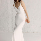 Model wearing a white Amalfi gown with a square heart neckline and a fluid bias cut skirt, and an open back with fabric-covered button detail.