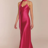 Woman wearing a pink satin gown with a plain background