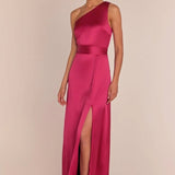 Woman wearing a pink one-shoulder gown with a slit on a beige background