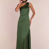 Woman wearing a green one-shoulder dress with a slit on a beige background