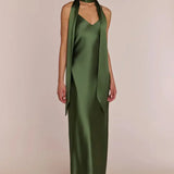 Woman wearing a green satin halter neck with REWRITTEN Brooklyn strappy-slip Bridesmaid Dress in Olive Green against a plain background